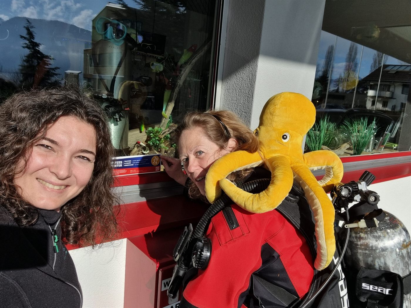 Claudia und Karin mit Otto, dem Plüsch-Tintenfisch, vor der Tauchbasis